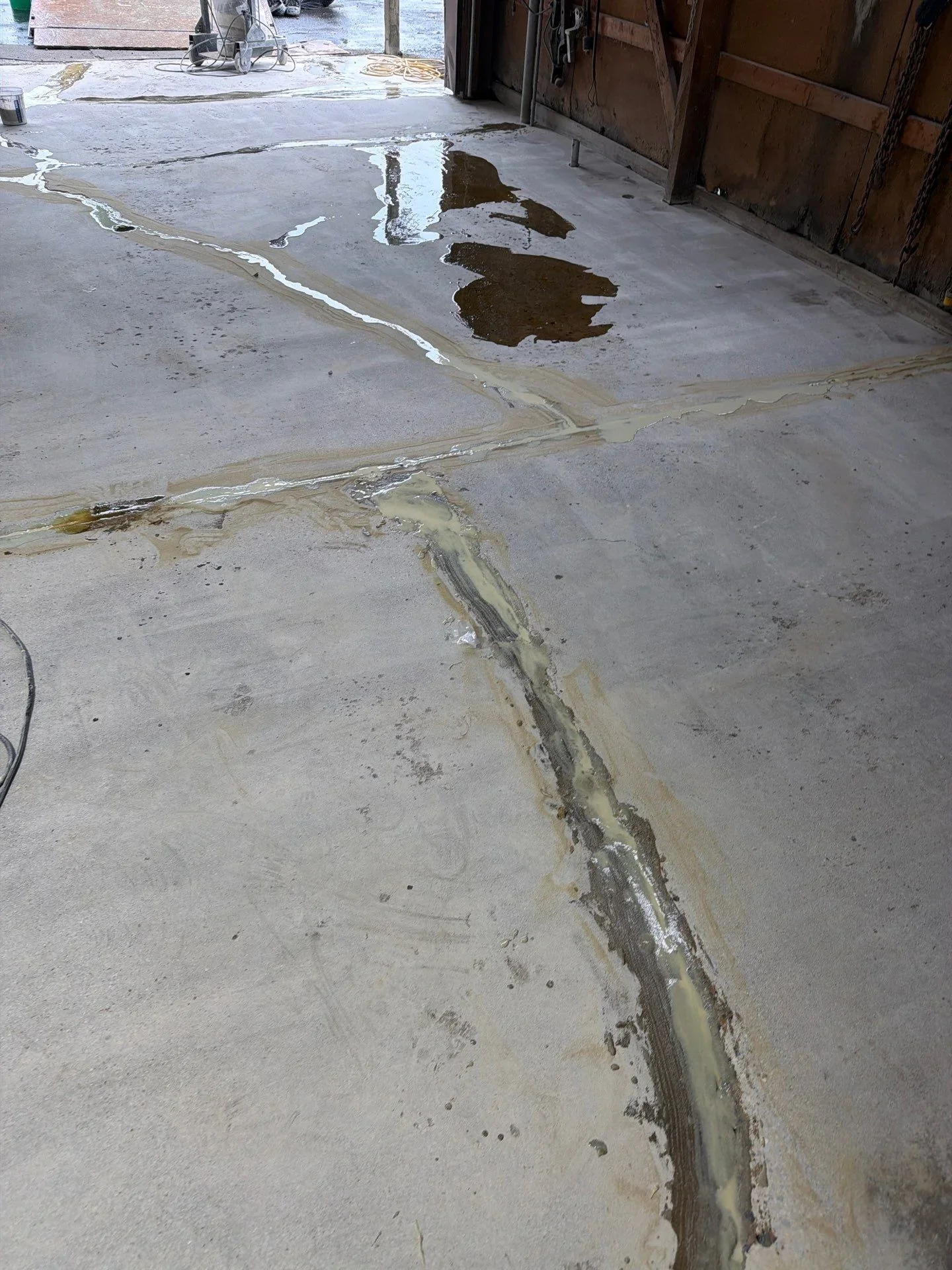 Concrete floor with epoxy primer lines and grinding marks during industrial coating preparation