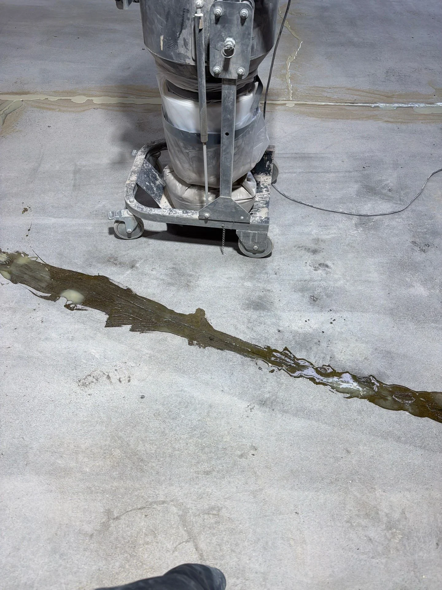 Industrial floor cleaning machine removing algae and debris from concrete surface