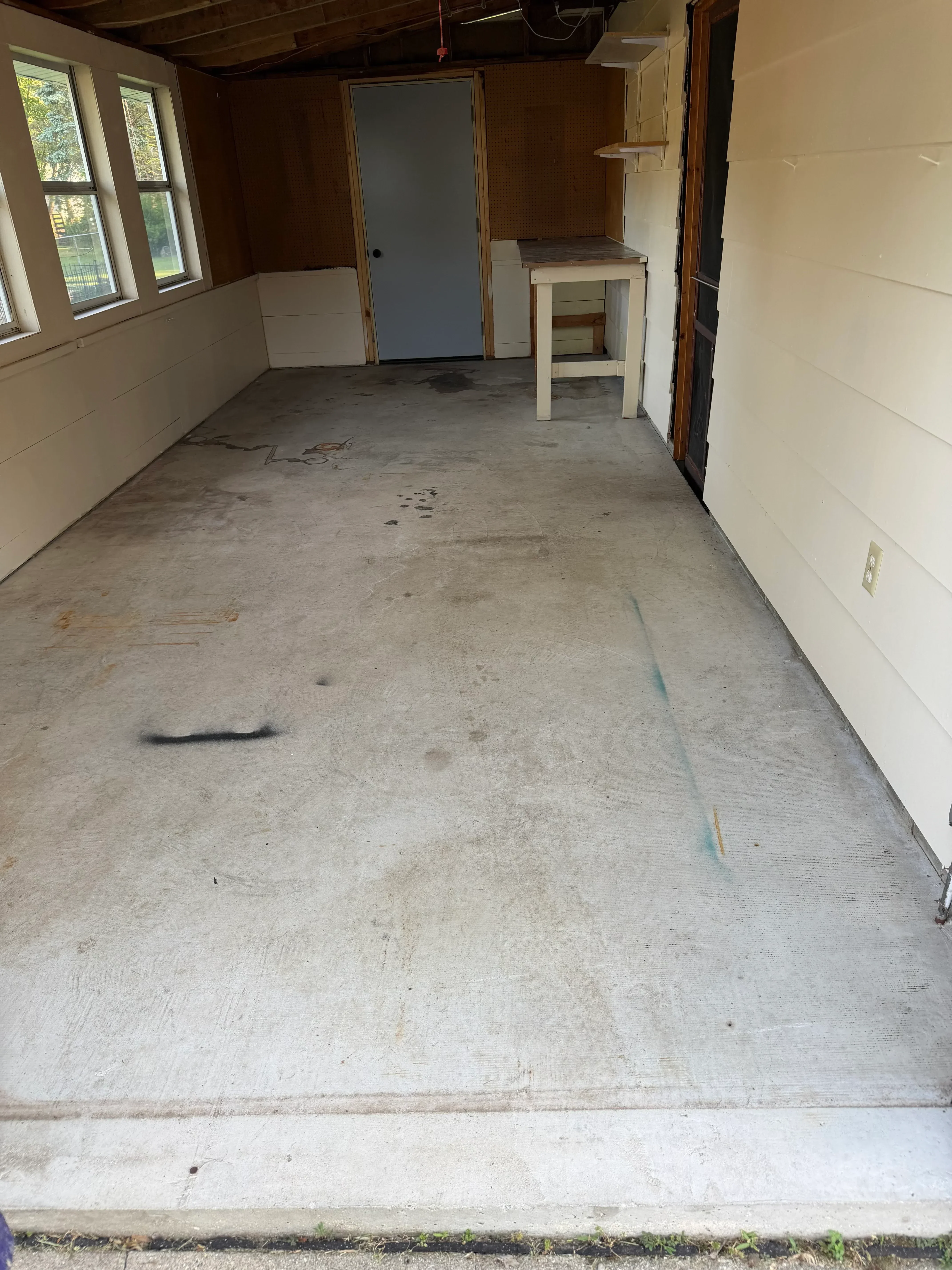 Bare concrete wall with preparation marks, white drywall ceiling with recessed lights above