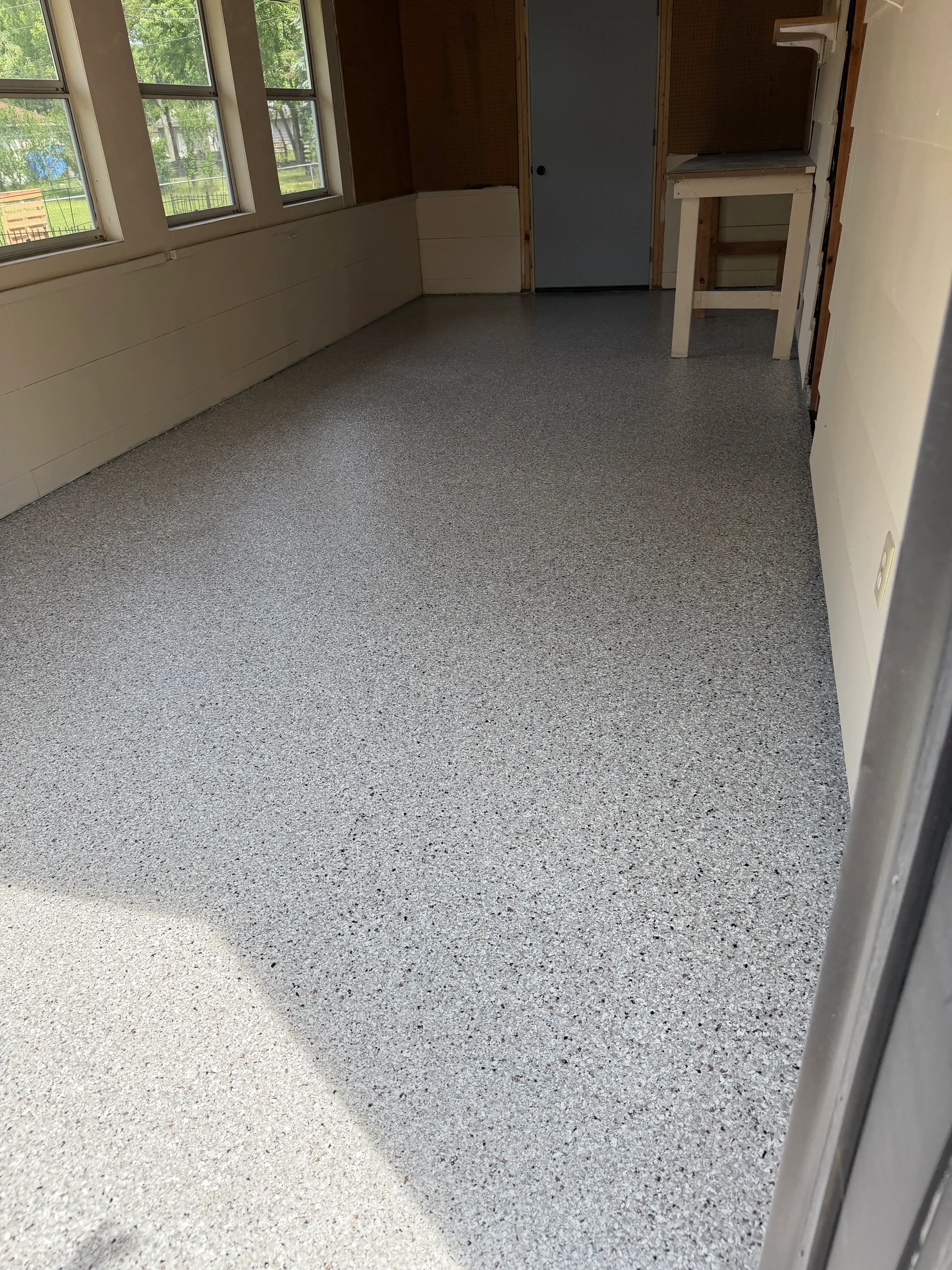 Gray speckled epoxy-coated garage floor with seamless finish
