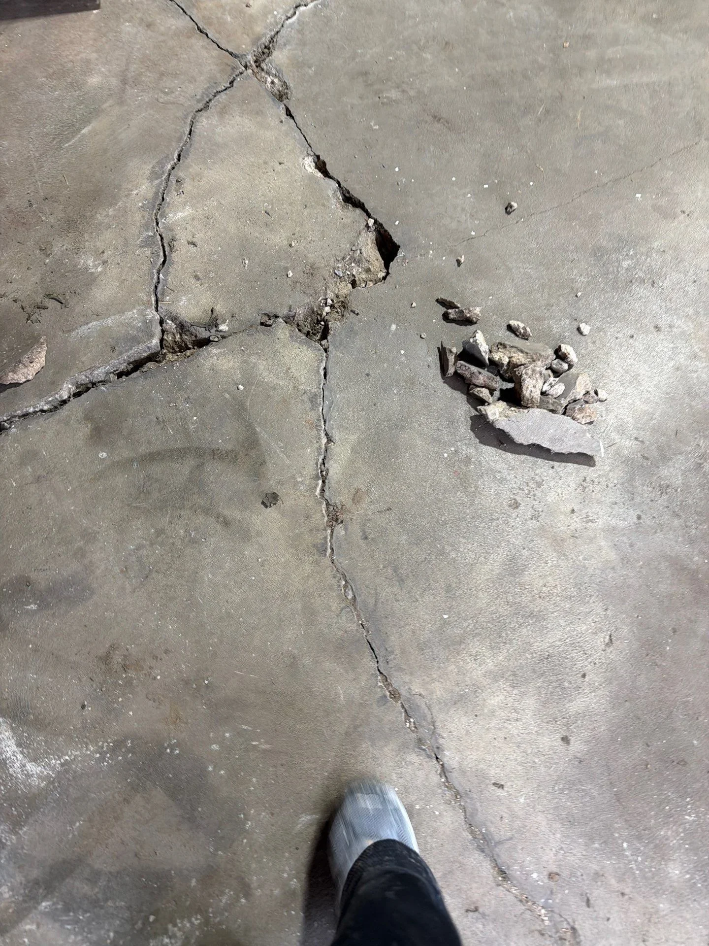 Concrete slab with deep cracks and spalling damage, broken concrete pieces removed