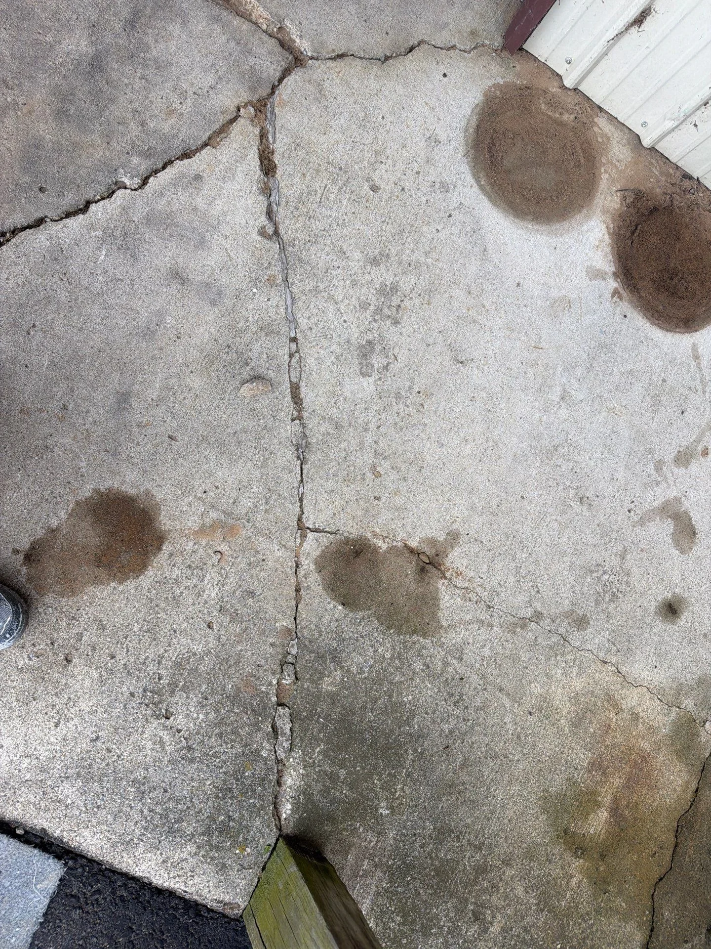Cracked and spalled concrete slab with deep fissures and surface deterioration