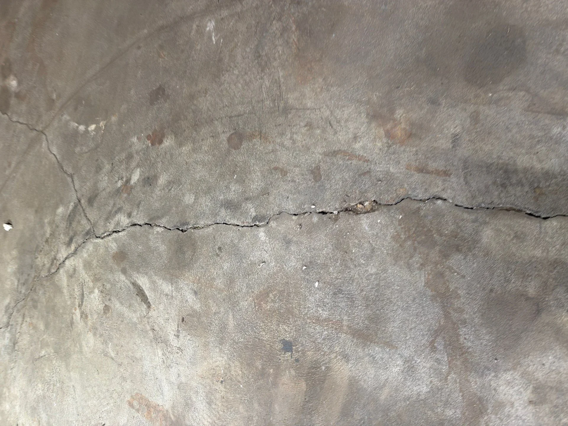 Sealed concrete crack repair on gray concrete surface with weathered finish