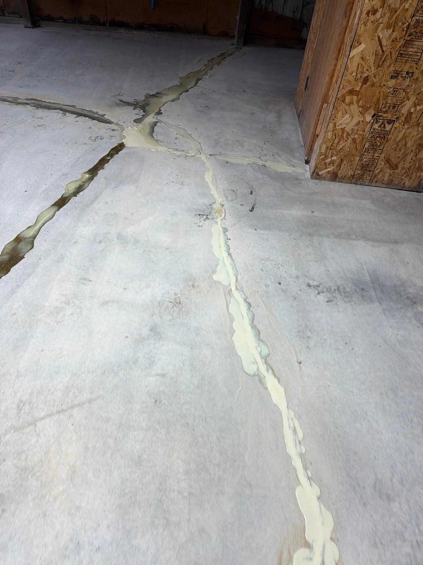 Concrete floor with sealed cracks using light-colored polyurethane sealant