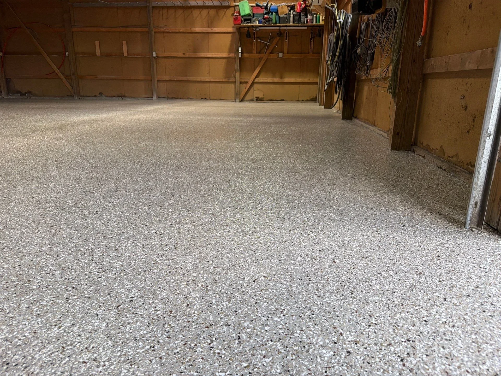 Finished garage floor with light gray epoxy coating and aggregate texture