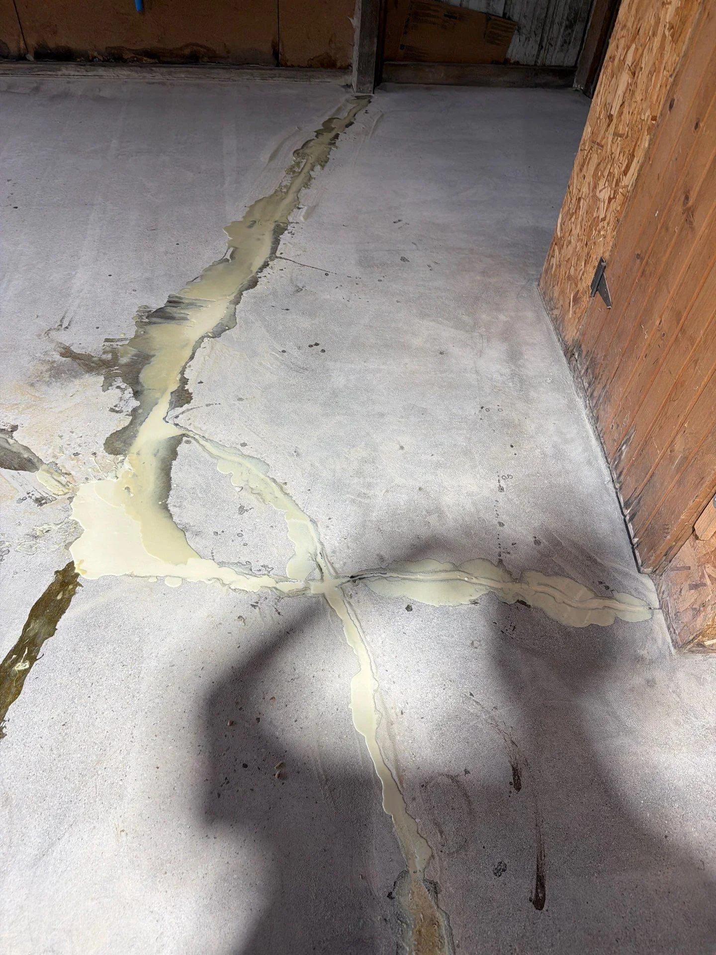 Concrete floor with sealed crack using yellow epoxy or polyurethane filler material