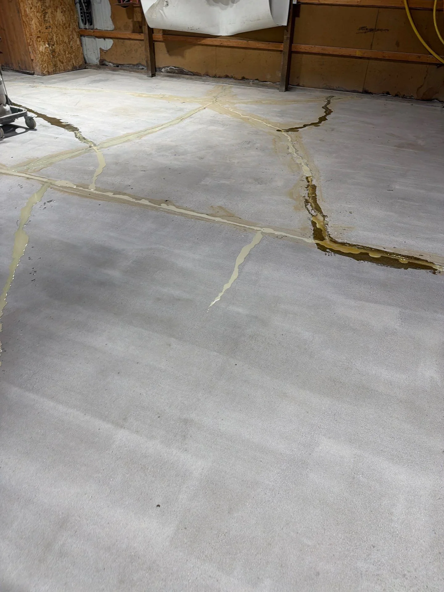 Concrete floor with yellow-marked cracks and deteriorated areas ready for repair