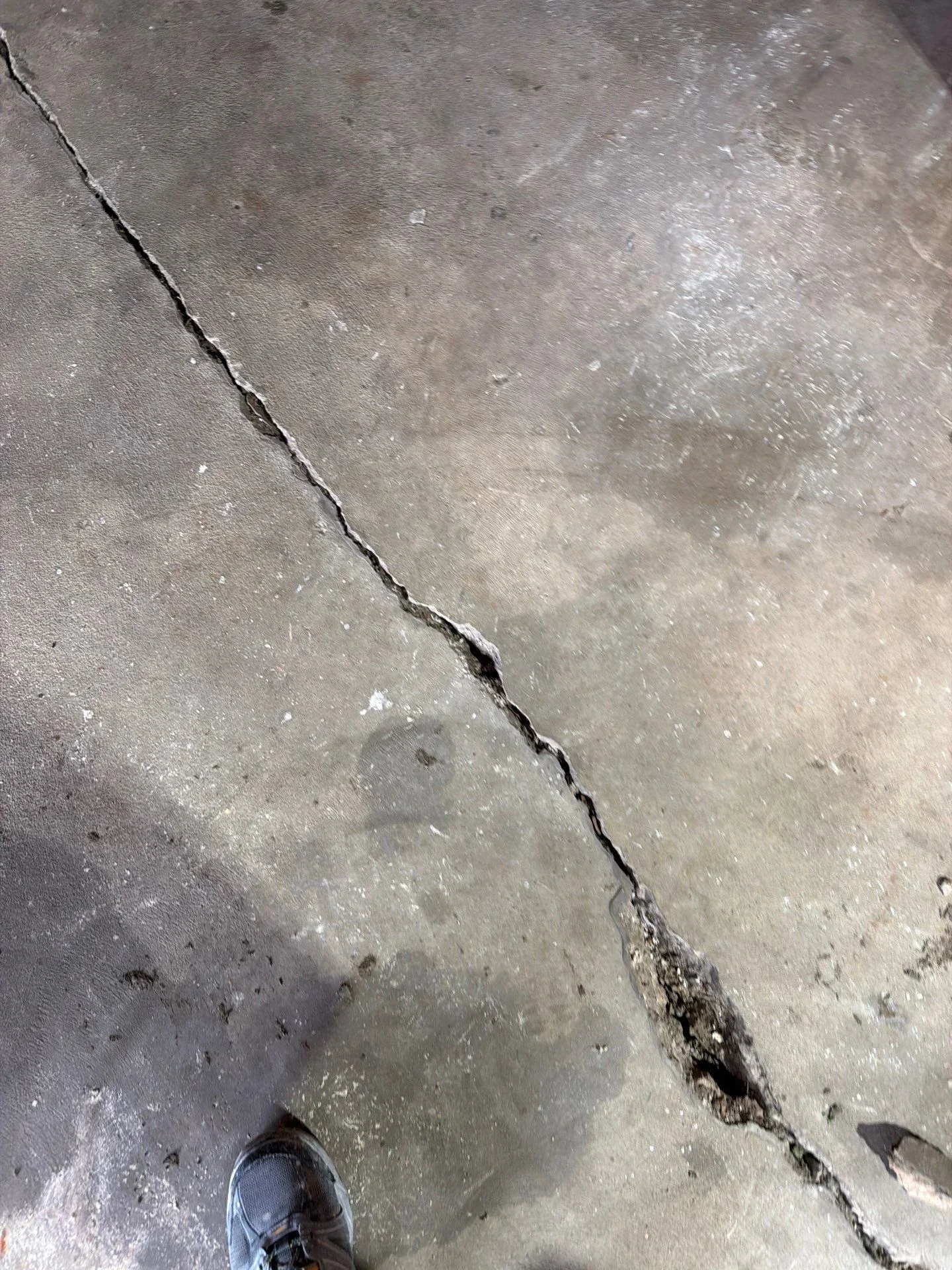 Sealed concrete crack repair on gray concrete surface with visible repair material